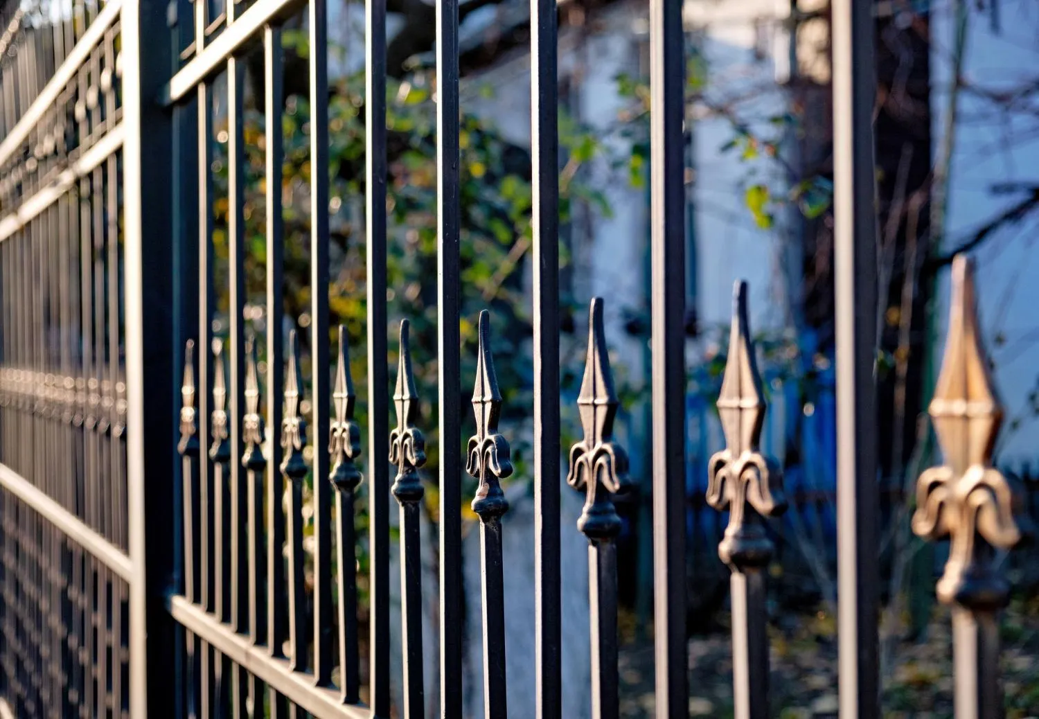 Close-up of black ornamental steel fence pickets with spear tops